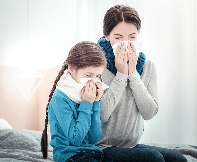 Family illness. Ill exhausted sad natives being in the bedroom sneezing and closing their eyes.