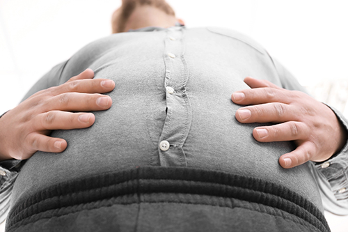 Fat man on white background, closeup. Weight loss concept