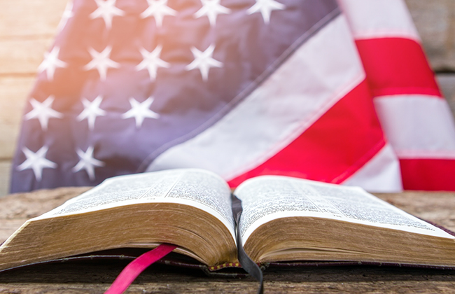 Open book and american flag. Open book on wooden surface. Value your independence. Freedom for every man.