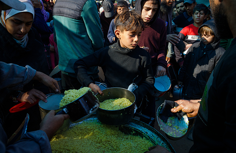 Palestinians try to get a free meal (from a charity restaurant) in a temporary displacement camp after the decision to close the American World Kitchen for the second day in a row, which exacerbated the plight of displaced Palestinians in the southern Gaza Strip, on December 2, 2024.(Photo: Mohammed Skaik/News Images)